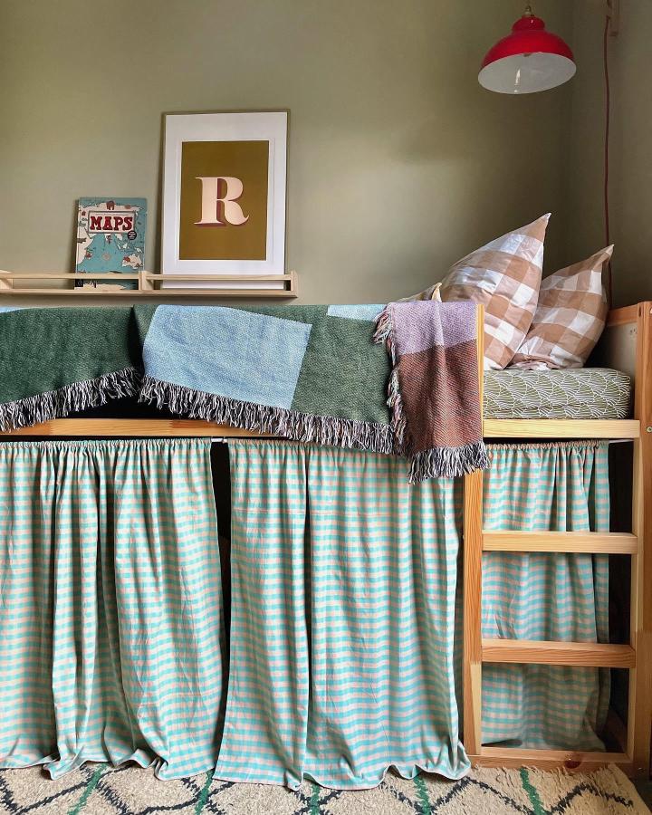 Turquoise striped IKEA KURA playroom bed from @all_the__things. Curtains create a cozy hideaway below.