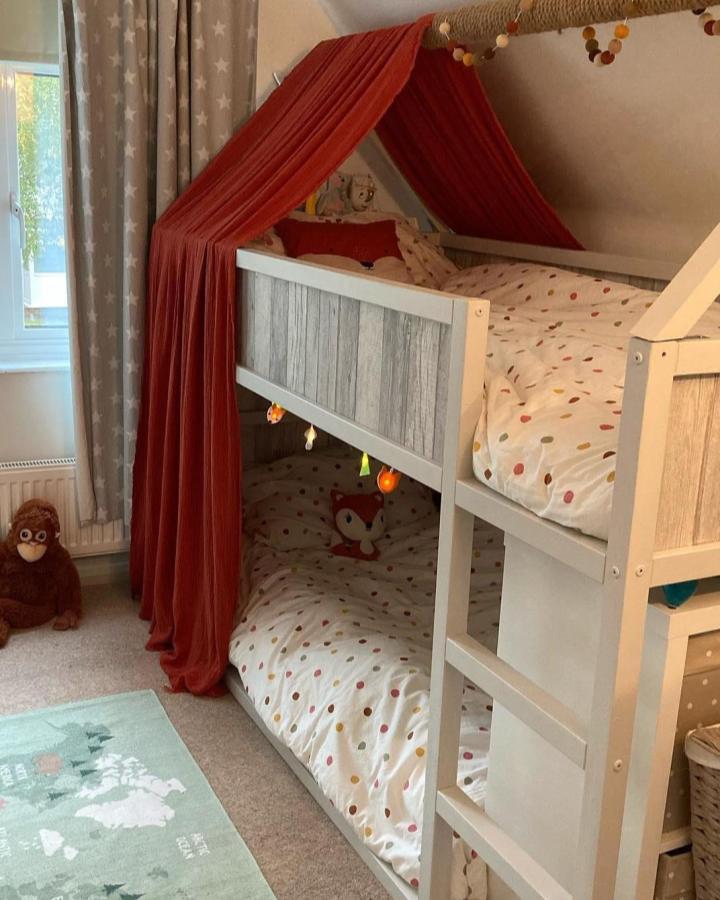 Red canopy shared bunk from @home_with_helen_andco featuring ikea kura bed ideas for shared rooms and dotted bedding.