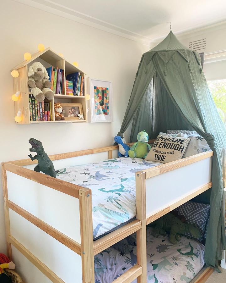 Sage canopy raised KURA bed from @gillianellen_creations. Shared bedroom nook with dinosaur bedding and toy storage.
