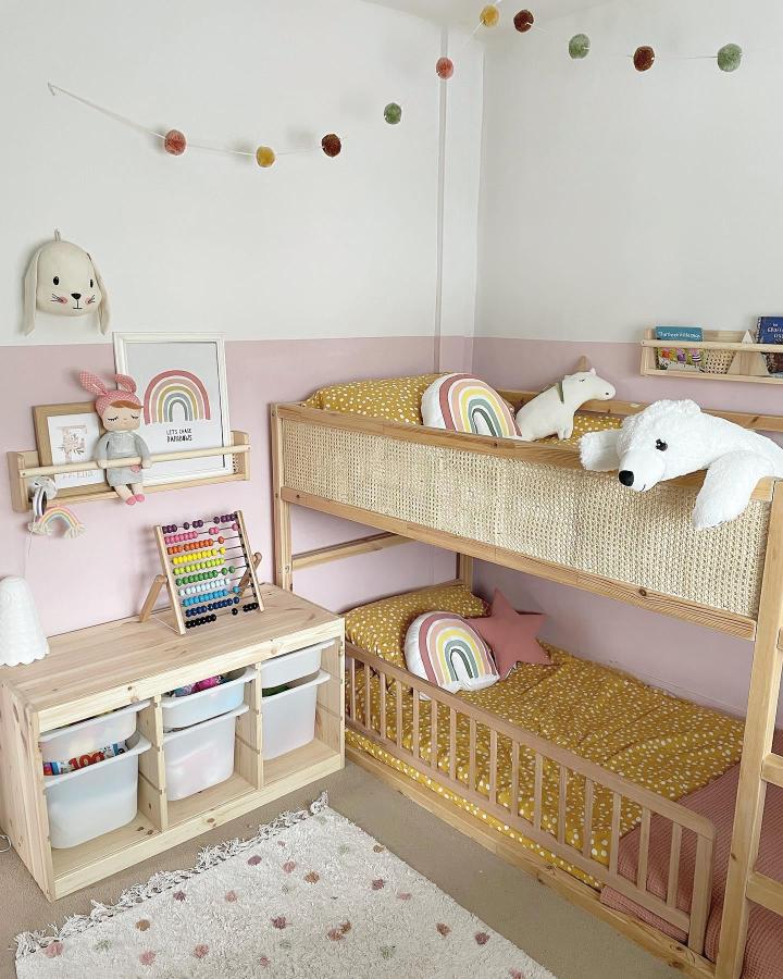 Natural wood bunk beds from @our_littlegreyhome. Shared childrenโs room with rattan panels, dusty pink walls, and mustard bedding.