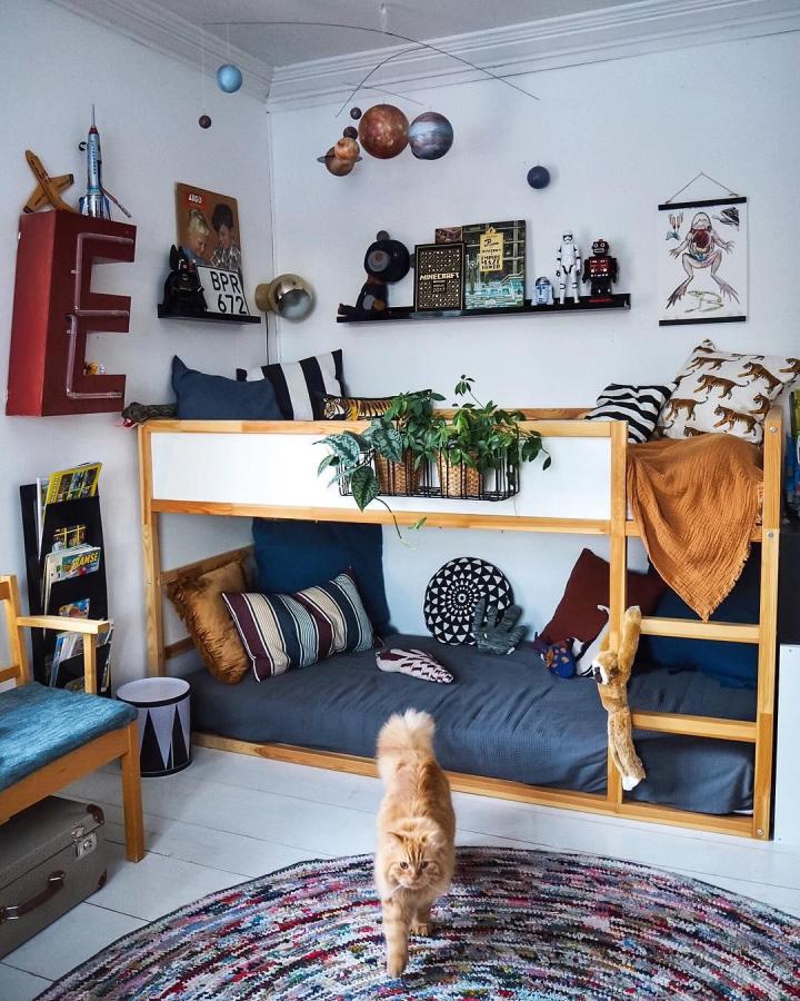 Natural pine bunk bed from @vi.flydde.storstan. Blue bedding, white panels, plants, and playful decor suit a shared childrenโs room.