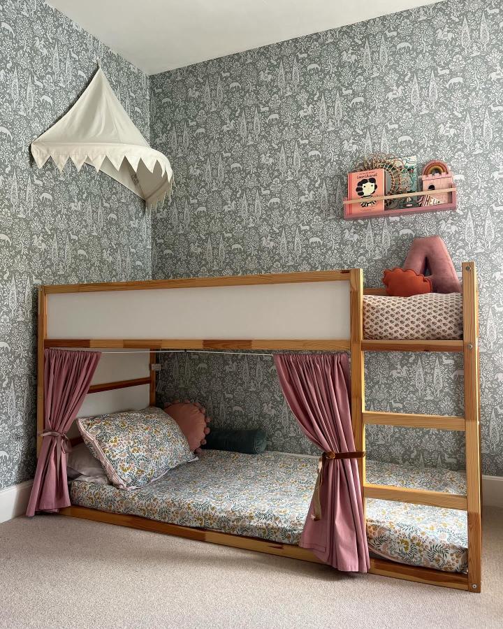 Dusty pink curtains and warm wood KURA bunk from @no.13luckyforsome. Floral bedding creates cozy shared sleeping spaces.