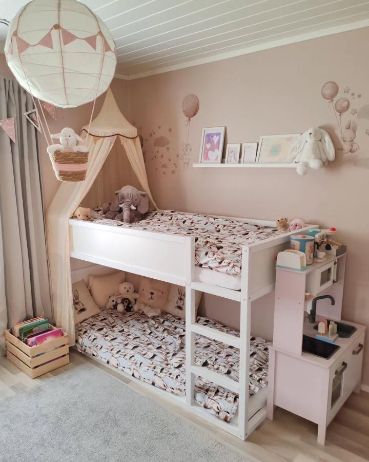 Blush pink and white bunk bed from @elinankodissa. Canopy, floral bedding, and toy kitchen share a cozy room.