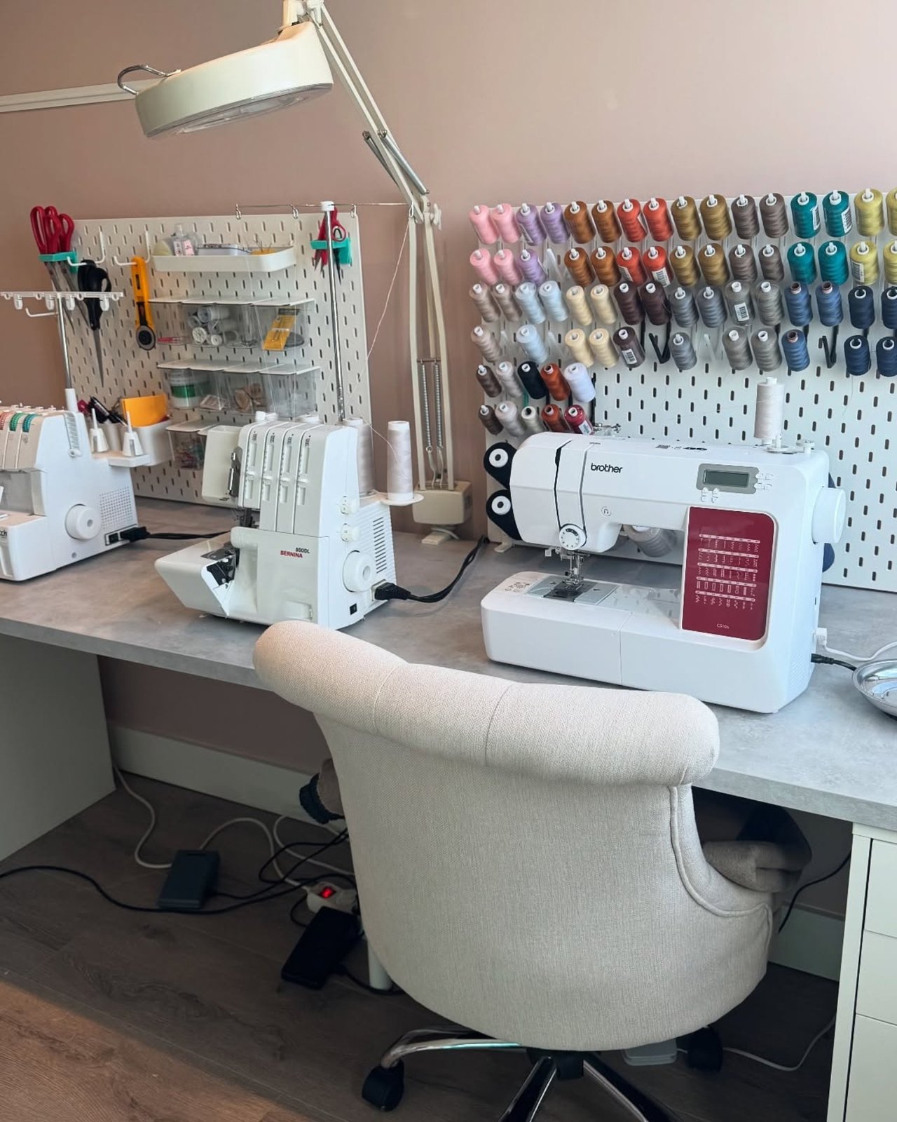 ikea skadis craft room ideas with color-sorted thread, sewing machines, clear bins, and organized tools