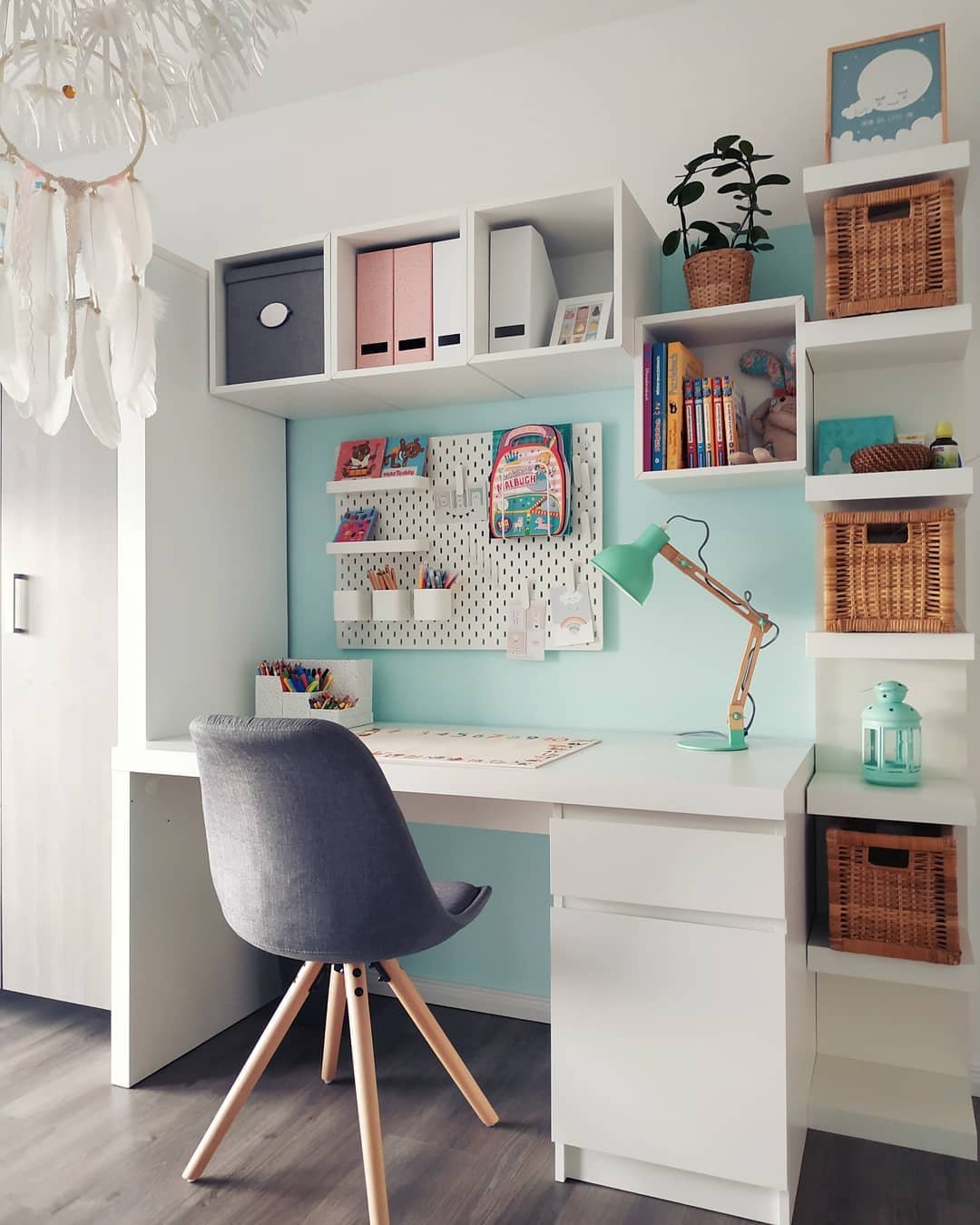 White pegboard craft station with colorful supplies, cube shelves, woven baskets, and a neat desk