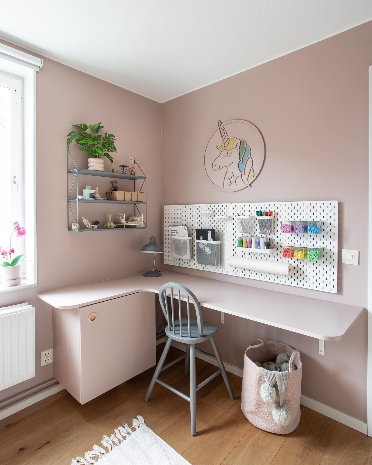 White pegboard craft station with colorful supplies, desk storage, and playful decor for a creative workspace