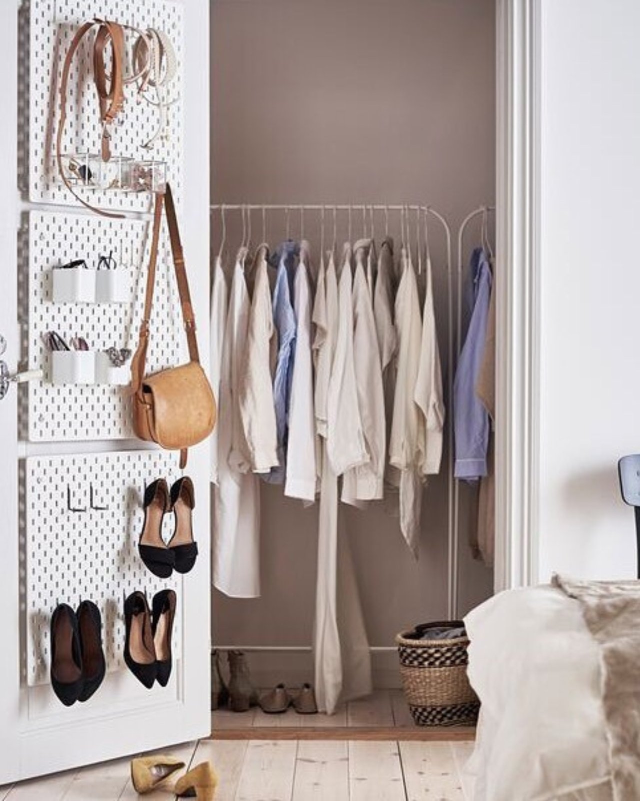 White pegboard craft storage on a closet door with hooks, shelves, shoes, bags, and organized supplies