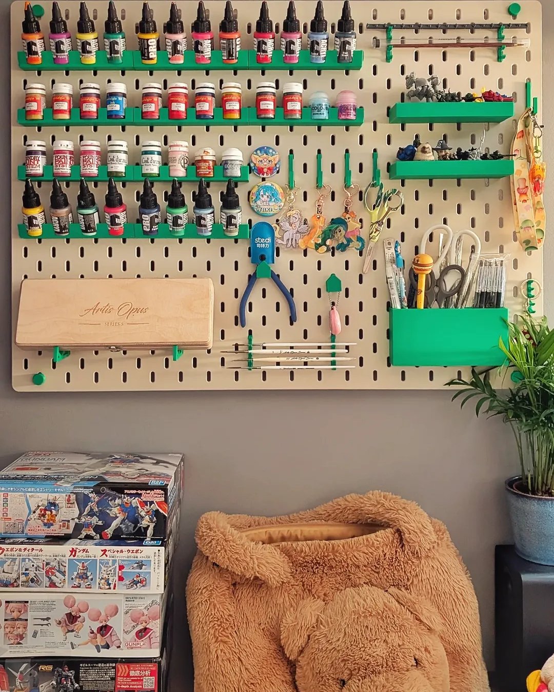 Pegboard craft room organizer with green shelves, paints, tools, and colorful creative supplies