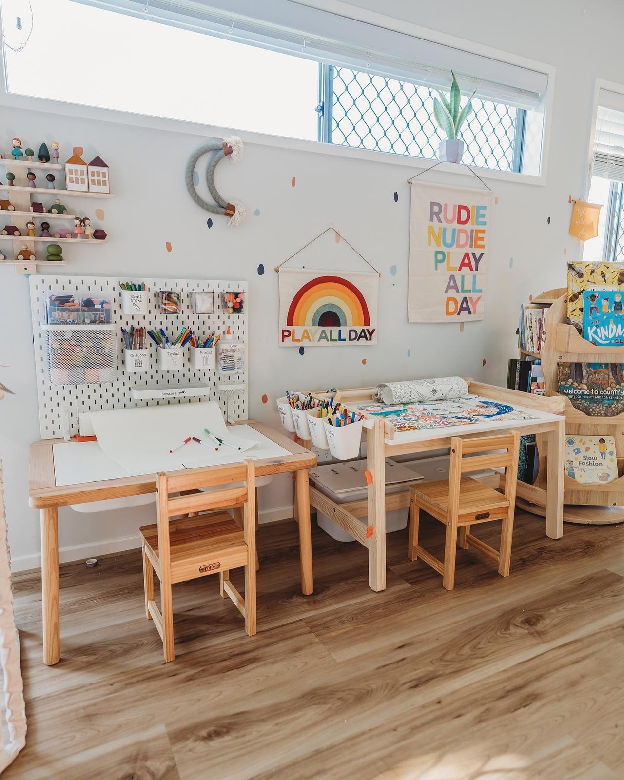 White SKADIS pegboard with labeled craft cups, art supplies, wooden tables, and colorful playroom decor