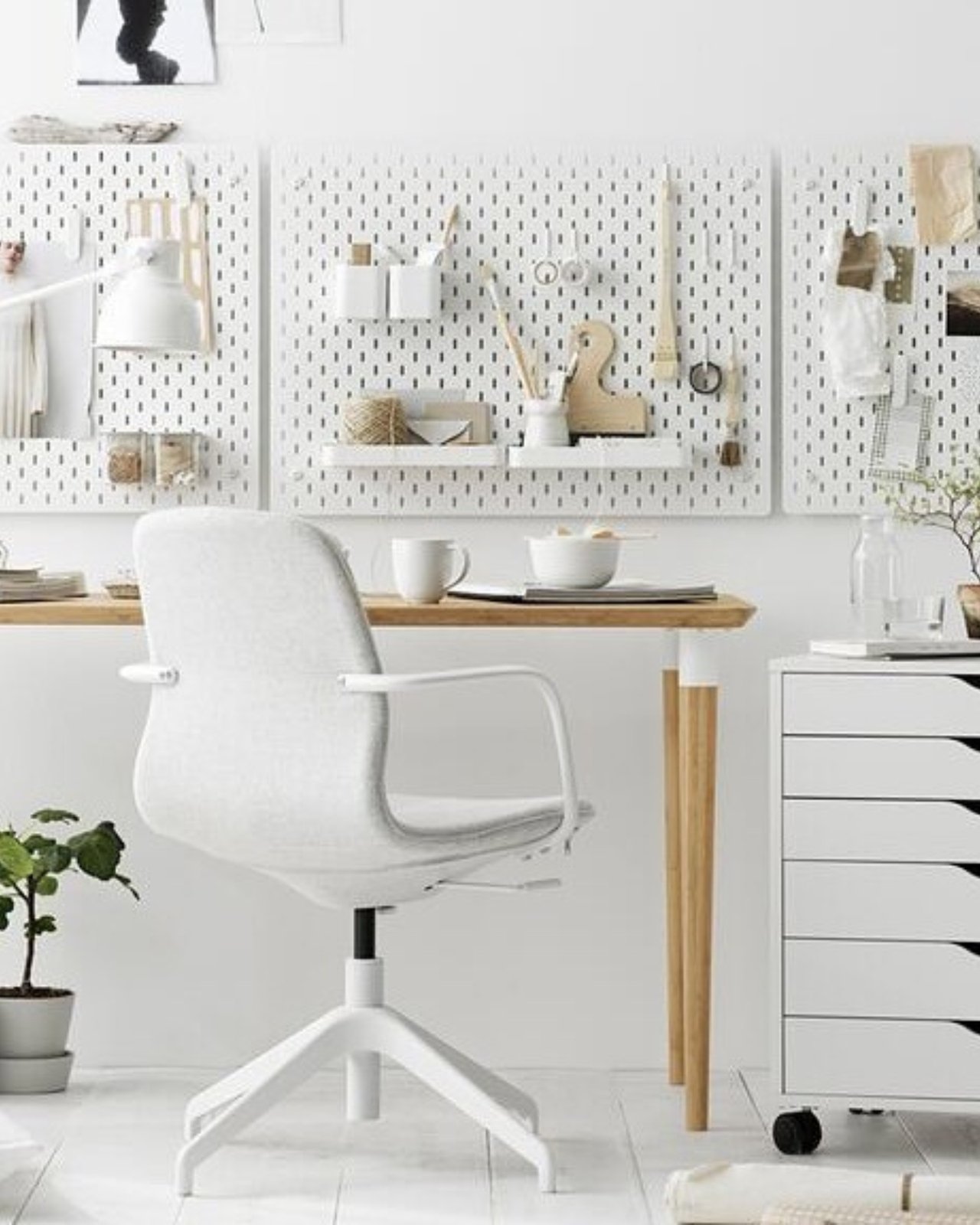 White pegboard craft station with shelves, containers, scissors, brushes, and neatly arranged creative supplies